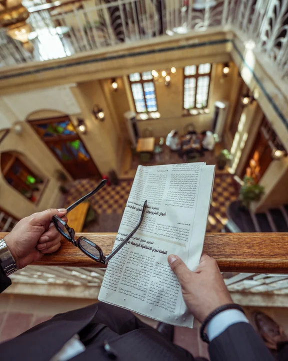 Businessman reading a newspaper on a hotel balcony in Iraq