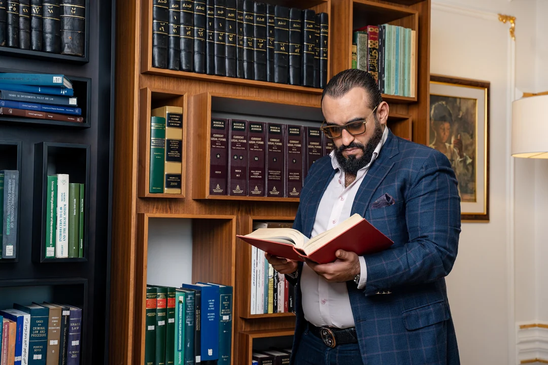 Lawyer reading a legal book among law library shelves